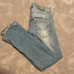 Ljusblå jeans med slitna detaljer - Säljer nu dessa dondup George jeans. Skick 6/10, små hål vid gylfen men inget man märker vid användning. Pris kan diskuteras.