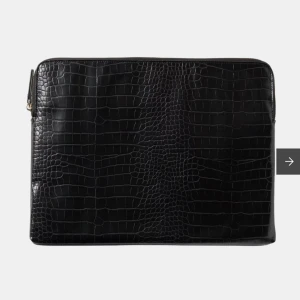 Svart datorfodral - Svart vadderat laptopfodral från Åhléns. Passar datorer på upp till 15 tum. Tillverkad i imitationsläder med struktur och stängs med dragkedja. Inuti finns ett huvudfack samt en öppen ficka på ena sidan och en korthållare på andra. Använd men i bra skick. Mått 34 cm x 25,5 cm. Supersnygg för skolan eller jobbet!🤩Priset kan diskuteras!🩷