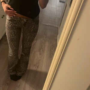  leopardmönstrade jeans  - Säljer jeans med leopardmönster och bootcut-snitt. Byxorna har låg midja och sitter snyggt över höfterna. Perfekta för dig som vill sticka ut med ett djurmönster och gillar en trendig look. Helt oanvända! 