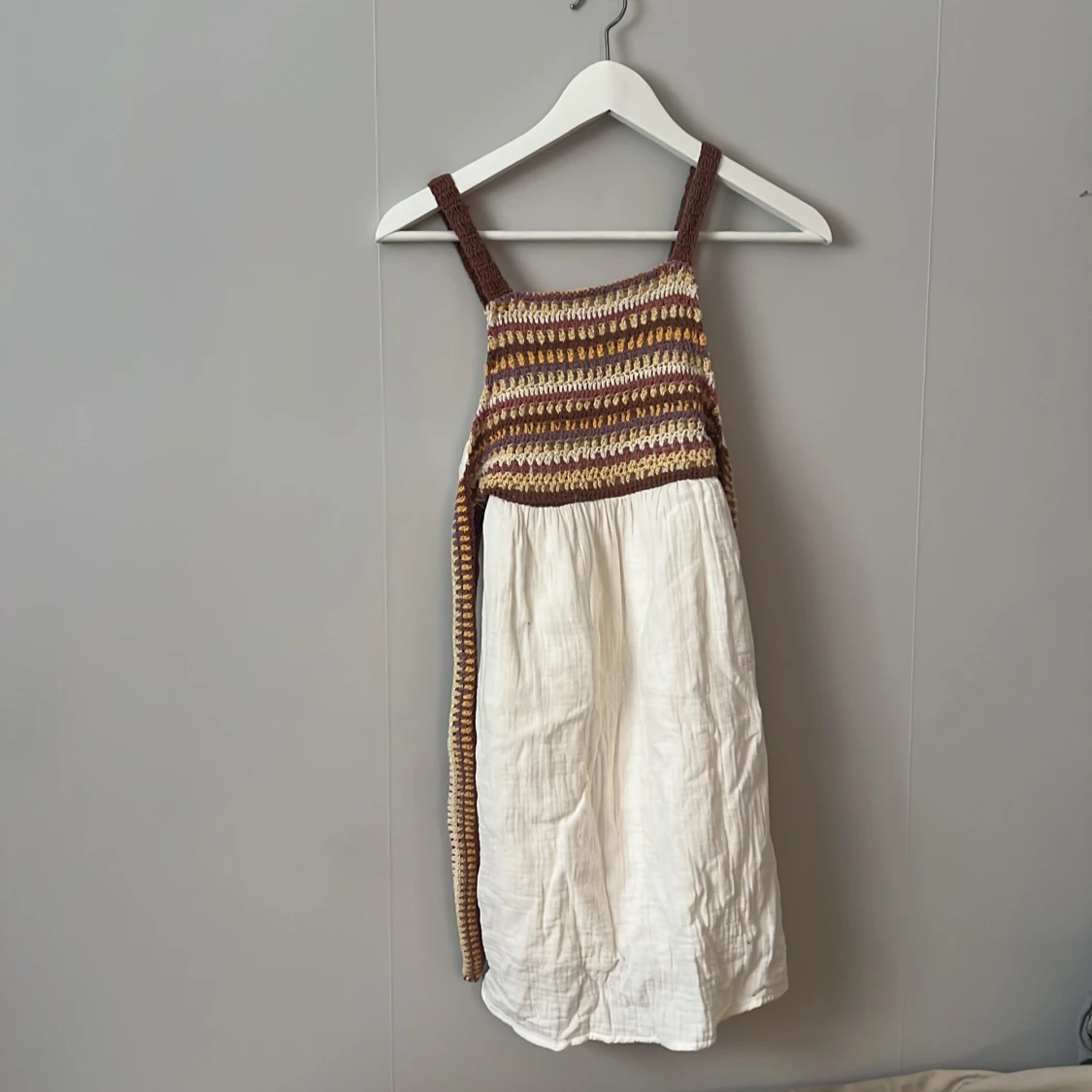 Vit och brun omlottklänning med virkade detaljer