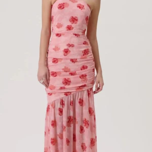 Ljusrosa blommig långklänning Adoore - Superfin ljusrosa långklänning från Adore med röda blommor och draperade detaljer. Klänningen är axelbandslös och har en figurnära passform upptill med volang nedtill. Perfekt för dig som vill sticka ut med en romantisk och trendig look.