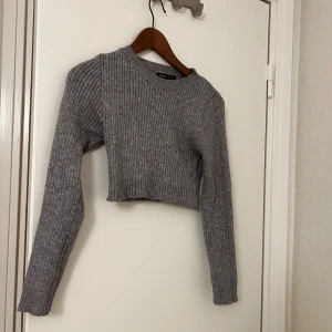 Grå croppad ribbad tröja  - Grå croppad stickad tröja från SHEIN med ribbat mönster. Tröjan har lång ärm.