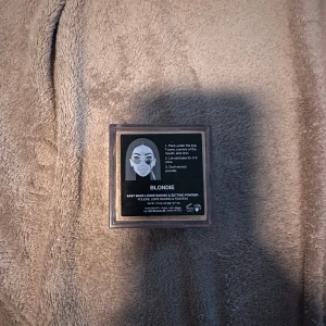 Huda Beauty Blondie Baking Powder - Lös puder i nyansen Blondie från Huda Beauty. Kommer i en fyrkantig transparent burk med svart lock och logga. Perfekt för att sätta sminket och ge en matt finish. Puderfärgen är ljusgul och passar för baking och setting.