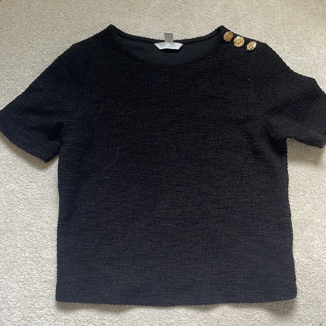 Svart topp med guldknappar från H&M