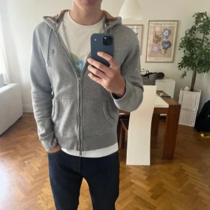 Burberry luvtröja - Säljer denna burberry tröjan som inte tillverkas längre i denna modellen med rutigt mönster i luvan. Den är i väldigt bra skick och är bra till att style. Tröjan är ett kvalitets märke från london. Perfekt i för hösten 