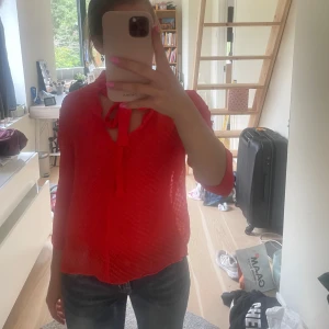 Röd blus med knyt  - Säljer en röd blus från & Other Stories med diskret prickigt mönster och knyt vid halsen. Blusen har trekvartsärm. På första bilden har jag den bak och fram men tycker nästan det är snyggare ❤️ Den är i storlek 40 men sitter som en S