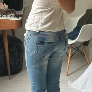 Ljusblå jeans från ONLY  - Säljer ett par ljusblå jeans från ONLY med snygga slitningar och tvättade detaljer. Jeansen  låg midja och raka ben. Materialet är mjukt denim med lite stretch. 