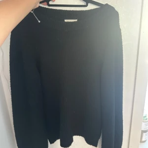 Svart stickad tröja från Object - En svart stickad tröja från Object i storlek S. Tröjan har en klassisk rund halsringning och långa ärmar. Perfekt för lager-på-lager och enkel att matcha med jeans eller kjol.