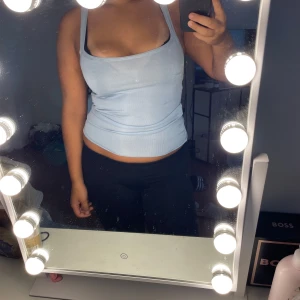 Ljusblå ribbad linnetopp från Mango - Supersöt ljusblå ribbad linnetopp från Mango med smala axelband och lätt croppad passform. Perfekt att styla med jeans eller kjol för en chill look. Materialet är mjukt och stretchigt för extra komfort.