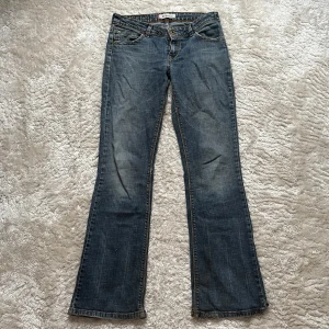Lågmidjade Levis jeans - Snygga lågmidjade jeans från Levis. Står ingen storlek men passar S skulle jag säga.  Midjemått: 38cm Innerbenslängd: 76,5cm Jeansen har några skråmor (se bilder)  Kontakta vid frågor