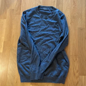 Grå merinoulls tröja Dressmann - En basic grå långärmad tröja från Dressmann i merinoull! Perfekt för lager-på-lager och enkel att matcha med jeans eller chinos.