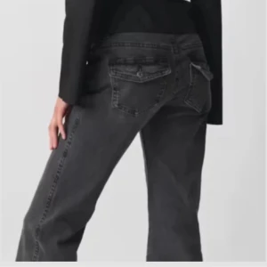 Gina low waist y2k jeans - Snygga svarta jeans från Gina Tricot i modellen low y2k. De har bootcut-ben, klassiska fickor med lock och knapp bak samt dubbla knappar fram. Det är lågmidjade🖤strl 36 och skulle säga att de passar s
