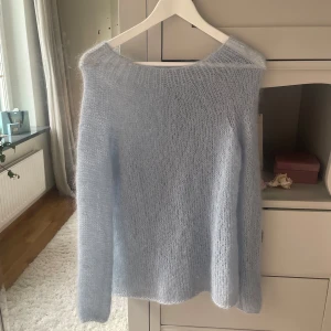 Ljusblå stickad tröja - Supermysig ljusblå stickad tröja med lång ärm och rund hals. Tröjan har en fluffig och mjuk känsla, perfekt för kyliga dagar. Enkel och stilren design som är lätt att matcha med jeans eller kjol.