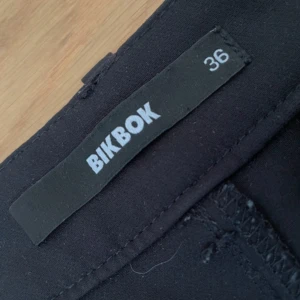 Svarta kostymbyxor från BikBok - Svarta kostymbyxor ifrån bikbok i storleken 36! Det finns slit nere vid benet som är väldig snygga, säljer dessa för de tyvärr inte passar. Om du funderar över något så är det bara att kontakta mi