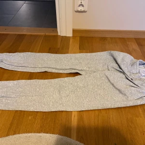 Grå mjukisbyxor från Gina  - Ljusgrå mjukisbyxor från Gina i storlek XS. Byxorna har resår i midjan och vid bensluten för en skön och avslappnad passform. Perfekta för chill dagar hemma eller när du vill vara extra bekväm.