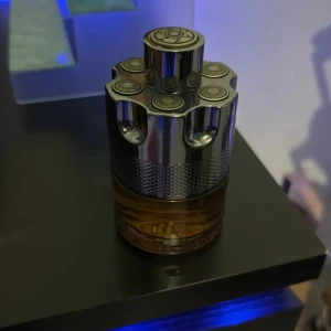 Azzaro Wanted  - Cool parfym från Azzaro i en unik flaska som ser ut som en revolvertrumma. Flaskan är i metall och glas med silverfärgad topp och bärnstensfärgad vätska. Perfekt för dig som gillar statement-detaljer på hyllan.