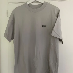 Ljusgrå Trapstar t-shirt - Säljer en stilren ljusgrå t-shirt från Trapstar med liten logga på bröstet. Vet ej fraktkostnaden.