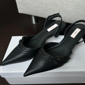 Svarta Nelly slingback klackar  - Svarta slingback klackar från Nelly i storlek 37 med supersnygga detaljer. Perfekta till hösten!🤩Använda bara en gång, så i jättebra skick. Skickas i Nelly skokartong. Priset kan diskuteras!🩷