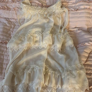 Vit volangblus med spets från STOCKH LM - En fin blus från STOCKH LM med flera lager volanger och spetsdetaljer. Den är ärmlös och har en luftig, flowy passform