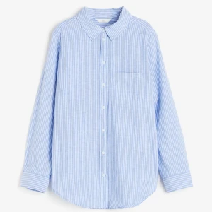Randig skjorta - Säljer en klassisk blå och vit randig skjorta från H&M. Skjortan har lång ärm, knappar framtill och en bröstficka. Perfekt för en avslappnad men ändå stilren look. I linneblandning!