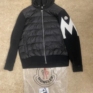 Moncler cardigan i storlek S/M - Moncler cardigan Med en M på armen   I nytt skick inga skador på den  Använd endast ett fåtal gånger 2-3   Kan fraktas vid överenskommelse finns i Kalmar   Koftan sitter bra båda på en storlek S och M  Fler bilder kan skickas   Koftan är: Stickad kofta Två glidfickor med knappstängning Stickad rygg och ärmar Nere på framsidan Fyllning: 90% dun och 10% fjädrar Bifogad logotyp på vänster ärm