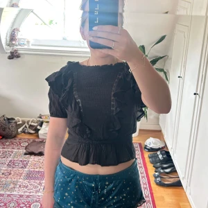 Svart volangblus Isabel Marant Étoile - Supersöt svart blus från Isabel Marant Étoile med volanger längs axlar och framstycke, korta puffärmar och knappar i ryggen. Tunn och luftig bomull med spetsdetaljer och lätt croppad passform. Kan tänka mig gå ner i pris!🥰