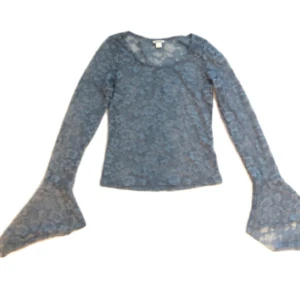 Blå spetsblus med utsvängda ärmar - Supersnygg blå blus i transparent spets med blommigt mönster. Långa utsvängda ärmar ger en unik och trendig look. Perfekt att styla med jeans eller kjol för en cool vibe.