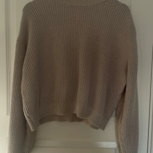 Beige stickad tröja från H&M - Säljer en beige stickad tröja från H&M. Tröjan har en avslappnad passform med långa ärmar och ribbade muddar. Perfekt för lager-på-lager och passar till många olika stilar. Skriv för fler bilder 