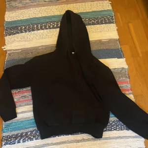 Svart hoodie med huva - En klassisk svart hoodie med huva och långa ärmar. 