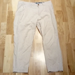 Becha line byxor från Jack&Jones 30\32 fresha - Snygga beiga chinos från Jack & Jones i storlek 30/32. Byxorna har klassisk passform med raka ben, sidfickor och bakfickor med knapp. Tillverkade i mjuk bomull, perfekta för en clean och avslappnad stil.