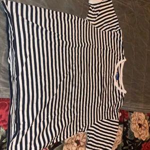 Randig t-shirt från Storm Cotton - Snygg t-shirt från Storm Cotton i storlek L med klassiskt svart och vitt randigt mönster. T-shirten har korta ärmar, rund halsringning och är gjord i mjuk bomull. Perfekt för en chill och stilren look.