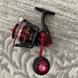 Baitcasting Reel 3000 - En snygg och modern rödsvart baitcasting-rulle, perfekt för dig som gillar fiske och vill ha en pålitlig utrustning. Passar både nybörjare och erfarna sportfiskare. Lätt att använda och designad för att ge en smidig fiskeupplevelse. Köpt för 319kr säljer nu för 199kr 