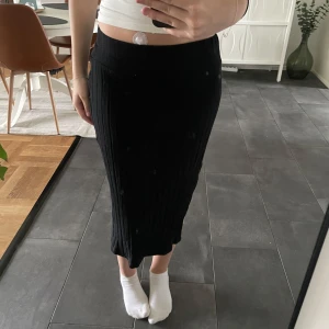 Ribbad svart midi kjol - Ribbad svart midi kjol med slit på sidan och tajt resår vid midjan. Bra skick och använd flera gånger. 💕