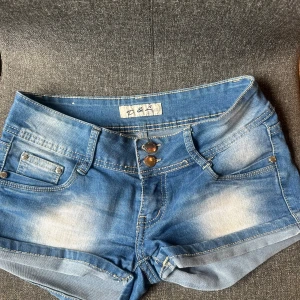 Blå jeansshorts med låg midja - Snygga blå jeansshorts från D&J med dubbla knappar framtill och klassiska fickor. Väldigt bra skick och nästan aldrig använda. 