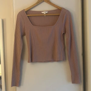 Ljuslila ribbad topp från H&M - Säljer en ljusrosa ribbad topp från H&M med lång ärm och fyrkantig urringning. Toppen är croppad och har en slim passform som sitter snyggt på kroppen. 