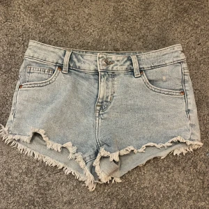 Ljusblå jeansshorts från H&M Divided - Snygga ljusblå jeansshorts från H&M Divided med fransig kant och klassisk femficksmodell. Shortsen har normal passform och är perfekta för sommaren.  Liteeeee highwaist ‼️