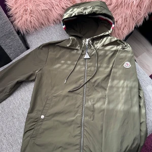 Grön moncler jacka - En fet moncler jacka i färgen grön perfekt till sena sommarkvällar! Väldigt bra skick utan några fel eller fläckar. Hör av dig vid intresse