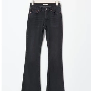 Svarta y2k bootcut jeans från Ginatricot  - Snygga svarta y2k bootcut jeans med  femficksdesign från Ginatricot. De har en knapp och dragkedja framtill och även knappar på bakfickorna. Har används ca 3 ggr och är i bra skick, de är i storlek 38.