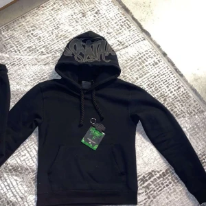 Svarta mjukisbyxor med brodyr och dragkedja - Svarta mjukisbyxor från Forgive Me med broderad text vid benet och coolt snörningsband i midjan. Byxorna har dragkedja vid benslut och en relaxed passform. Perfekta för chill dagar eller streetwear-stil.