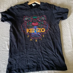 Kenzo t-shirt svart - Svart t-shirt från Kenzo med det vanliga tigertrycket på. Självklart äkta. Använd fåtal gånger. Stilren och snygg perfekt till sommaren.