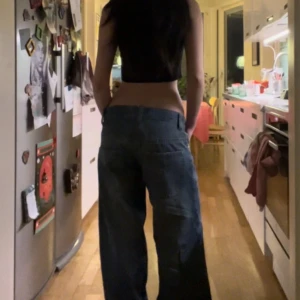 Blå low raised jeans från Blake - Säljer ett par blå jeans från Blake med riktigt breda ben och låg midja. Klassisk femficksmodell med dragkedja och knapp framtill. Perfekta för dig som gillar baggy och avslappnad stil.