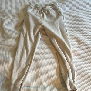 Beige mjukisbyxor från Zara - Beiga mjukisbyxor från Zara med resår i midjan och snörning. Byxorna har ribbade muddar vid bensluten och är tillverkade i mjukt bomullsmaterial. Perfekta för chill dagar eller när du vill vara extra bekväm.