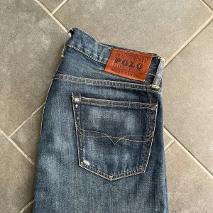  Polo Ralph Lauren jeans - Säljer ett par blå jeans från Polo Ralph Lauren med snygg slitning och raka ben. Storlek W30 L30, mycket fint skick. Retail ca 2000 kr.