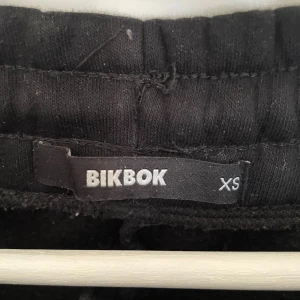 Svarta mjukisbyxor från BikBok XS - Svarta mjukisbyxor från BikBok i storlek XS. Byxorna har en bred resår i midjan och raka ben. Perfekta för en chill och avslappnad stil. Tillverkade i mjukt material som känns skönt mot huden.