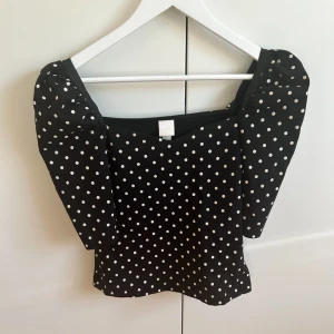 Svart prickig topp med puffärm  - Superfin svart topp från H&M med vita prickar och puffärmar. Tyvärr för stor för mig💕💕
