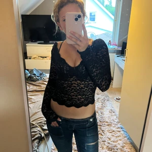 Svart spetsblus från Zara - Säljer en svart, croppad spetsblus från Zara med långa ärmar och v-ringad blus. Perfekt för dig som vill ha en edgy och trendig look.