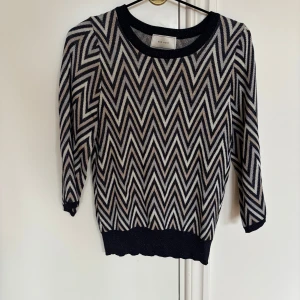 Mönstrad stickad tröja från Neo Noir - Snygg stickad tröja från Neo Noir med blå och beige zigzag-mönster. Tröjan har rund halsringning, trekvartsärm och ribbade muddar. 