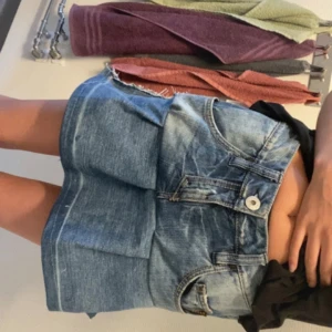 Blå volangkjol - Säljer en blå jeanskjol från Ragsty med  snören i midjan som man kan minska. Kjolen har stora fickor fram och klassiska jeansdetaljer som knapp och dragkedja. Den är gjord helt själv så den är inte perfekt. De sitter lite konstigt vid sidan men annars är den bra💕