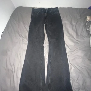 Svarta bootcut jeans från 157 - Svarta jeans från 157 med bootcut-passform och låg midja. Klassisk femficksmodell med raka ben som blir vidare nertill. Jeansen är tillverkade i denim och har en enkel, stilren look som passar till det mesta.