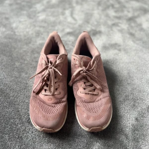 Rosa sneakers från Dkarn - Snygga sneakers i dammigt rosa från Dkarn med ventilerande mesh-ovandel och vita, mönstrade sulor. Skorna har snörning och en sportig vibe, perfekta för dig som gillar en clean och modern look. Lätta och bekväma för vardagsbruk eller träning.